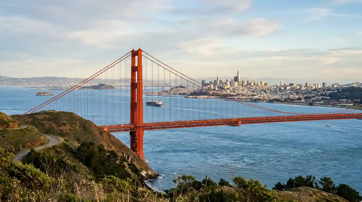 Golden Gate Bridge spanning San Francisco Bay under a clear afternoon sky.