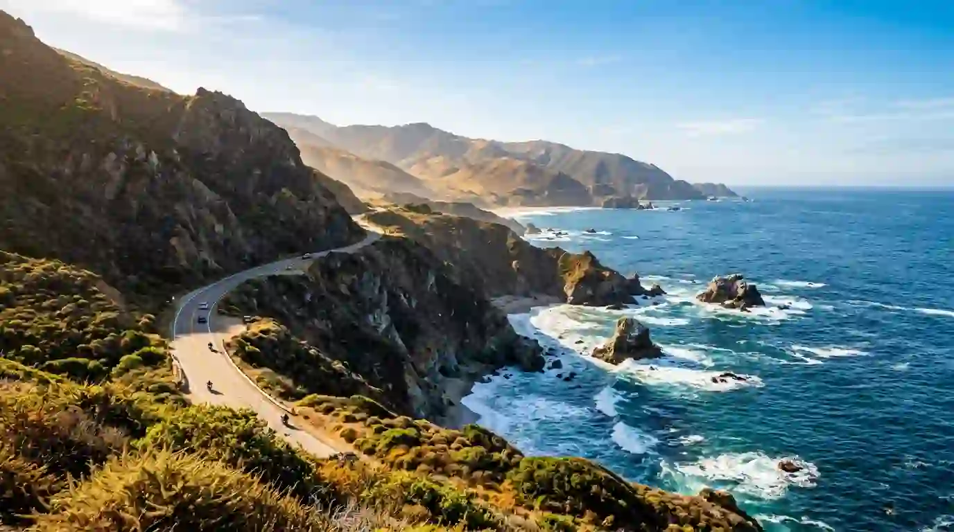 Rugged Big Sur coastline with ocean cliffs and a winding California coastal highway in summer.