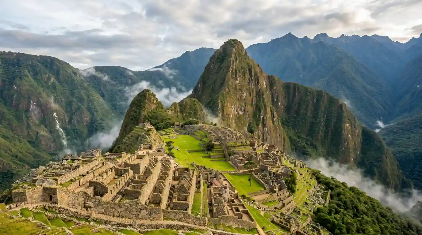 Ancient Machu Picchu ruins surrounded by the green peaks of the Peruvian Andes.