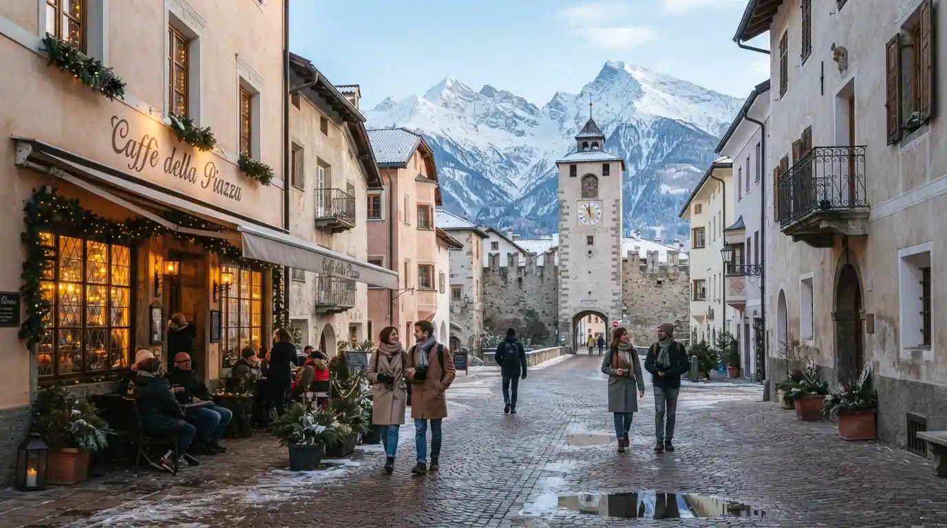 Snow-covered Alpine mountains overlooking a charming historic Italian town in winter.